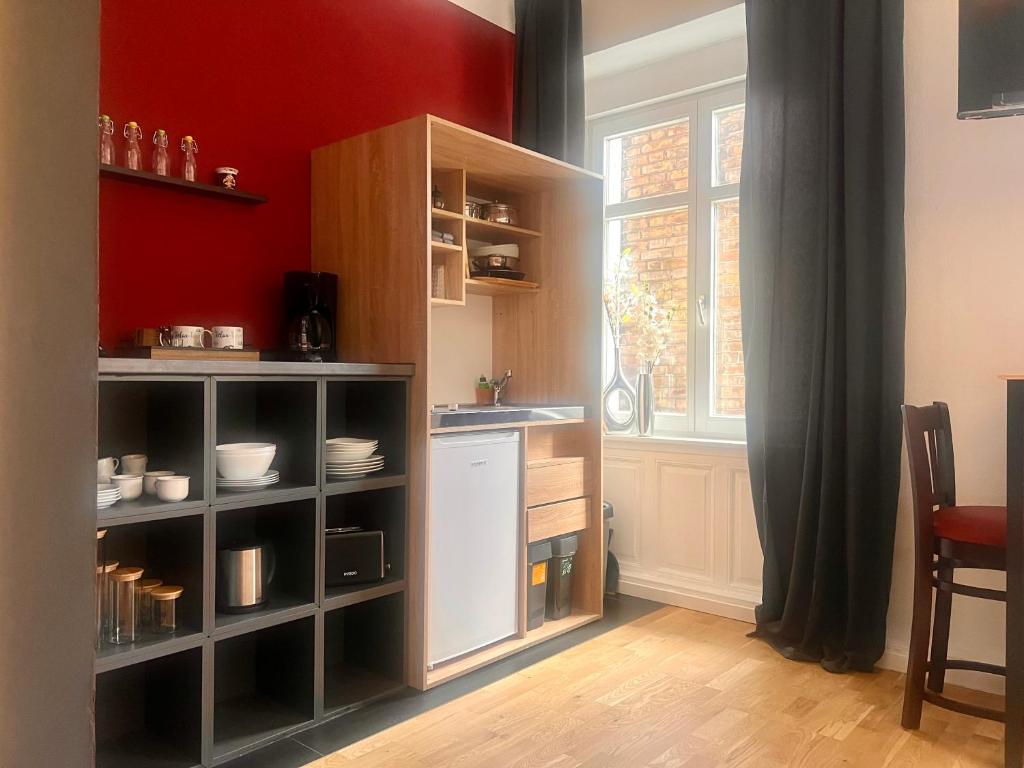 Küchenzeile mit Regal, Kühlschrank und Fenster zum Innenhof