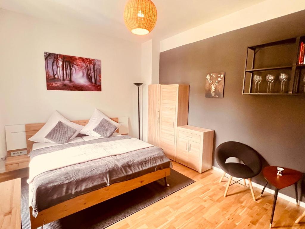 Wohn- und Schlafraum des Lichtental-Apart mit Doppelbett, Parkettboden und Sessel